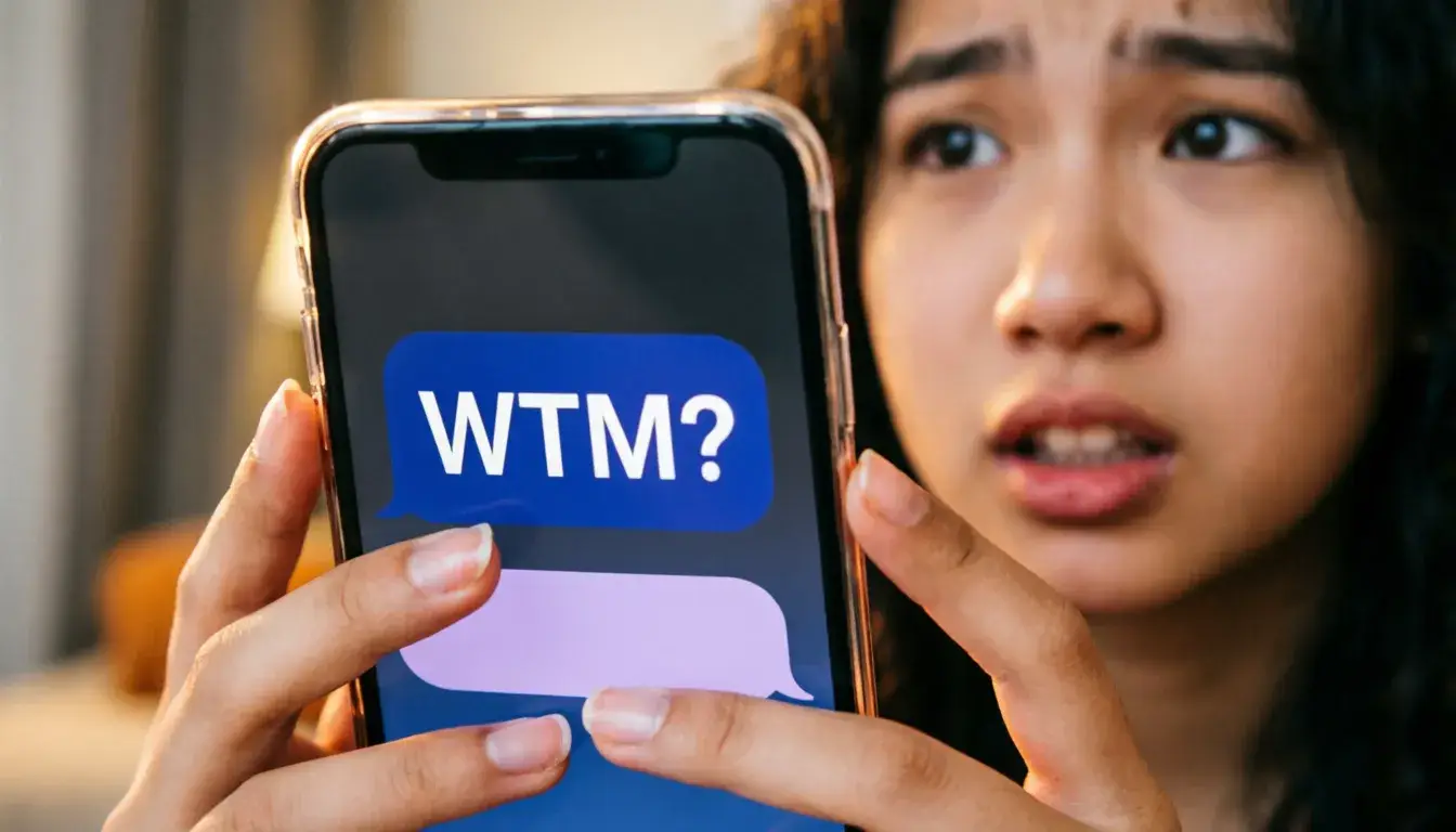Person texting WTM on smartphone wondering what does WTM mean in messages